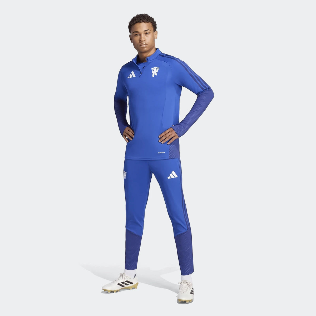 Male model wearing a full royal blue Manchester United 26/27 Cup Tiro training kit, featuring a quarter-zip top and matching
