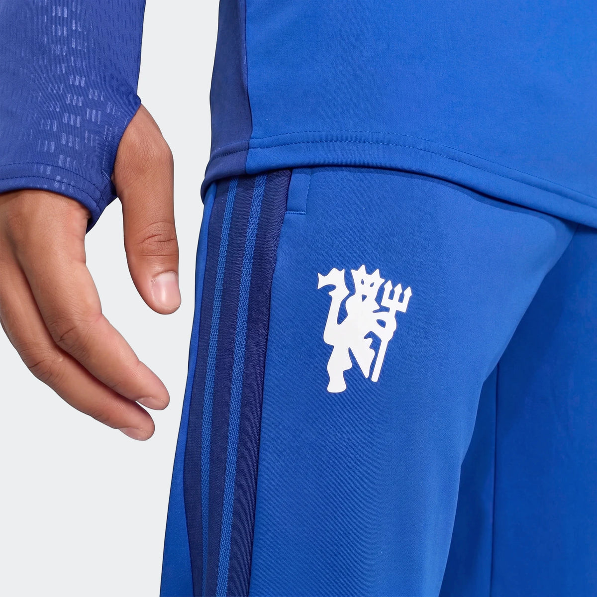 Manchester United 26/27 Cup Tiro Training Pants in blue, featuring the white club crest and Adidas 3-stripes.