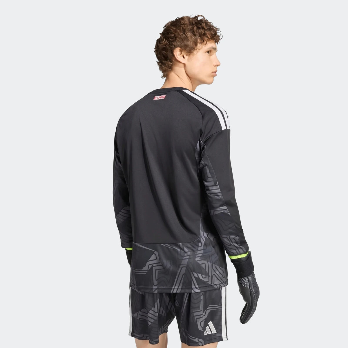 Back view of Manchester United 26/27 long sleeve goalkeeper jersey in black with white shoulder stripes and graphic hem.