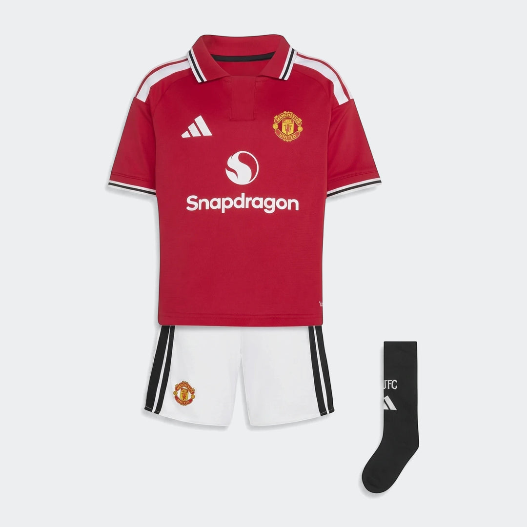 Manchester United 26/27 Home Mini Kit, featuring a red jersey with white collar, white shorts, and black socks, displayed