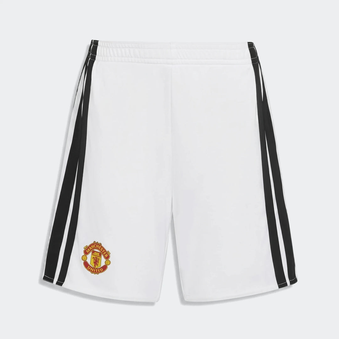 White Manchester United 26/27 Home Mini Kit shorts with black side stripes and official team logo, shown in a flat lay view.