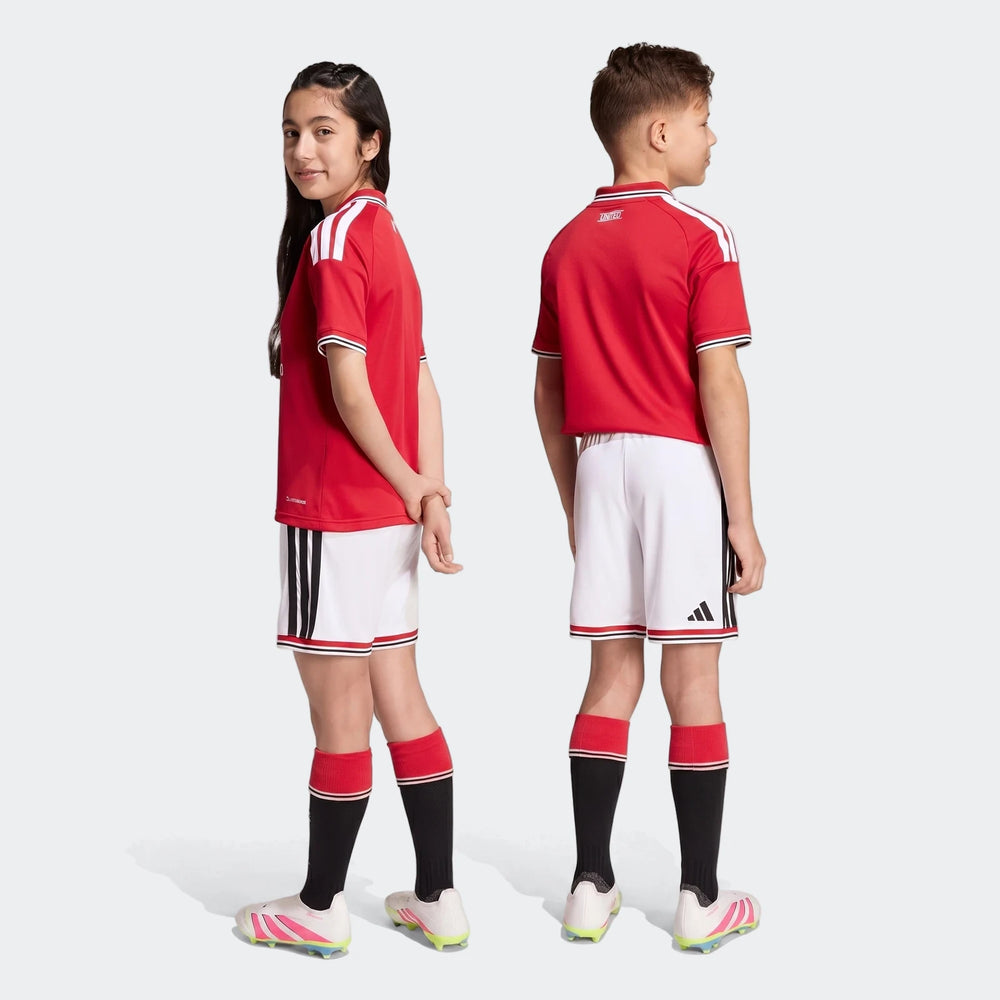 Manchester United 26/27 Home Shorts Youth in white with black side stripes and red trim, shown front and back.