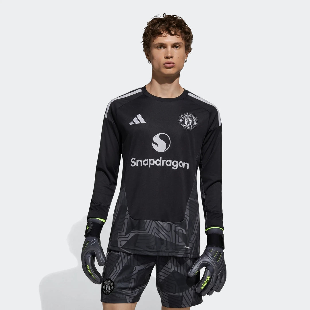 Manchester United 26/27 long sleeve goalkeeper jersey in black, front view with club crest and white shoulder stripes.