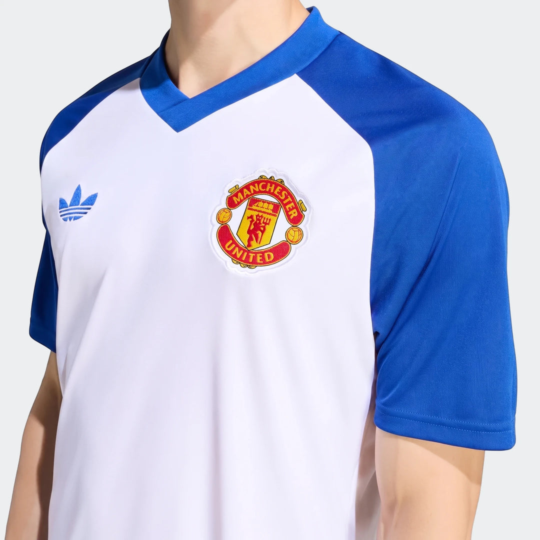 Close-up of a model wearing the Manchester United 26/27 Pre Match Jersey, featuring blue raglan sleeves and a white body