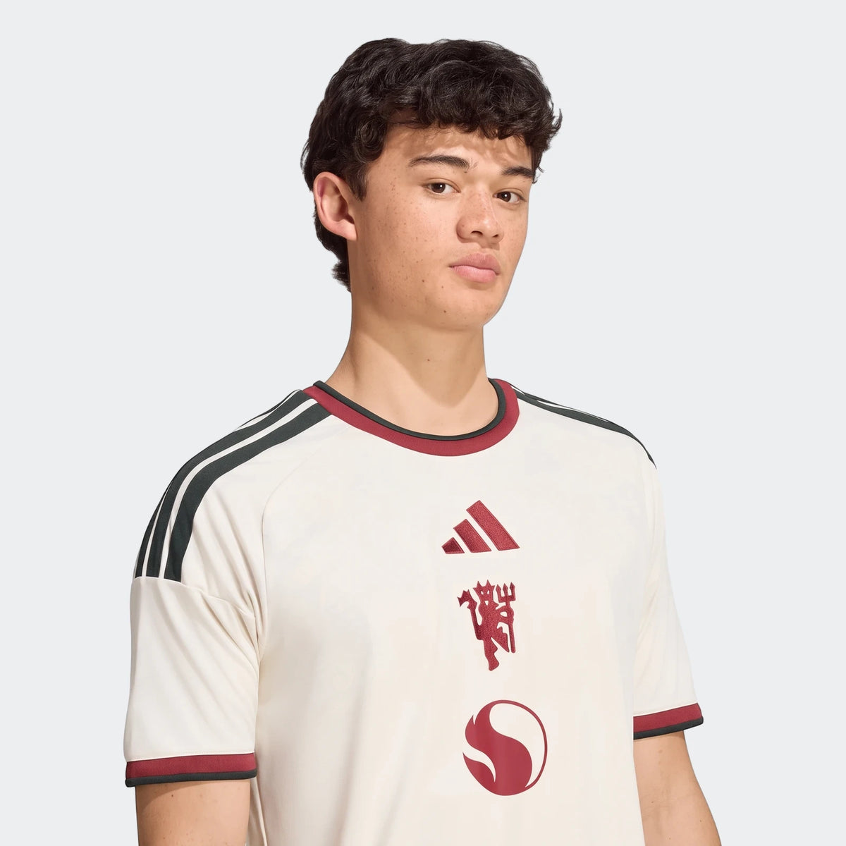Manchester United 26/27 Third Jersey in off-white, worn by a male model, close-up shot.