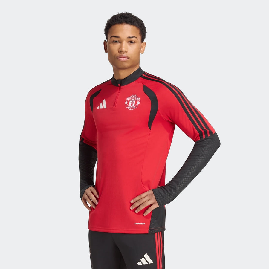 Young man wearing a red and black Manchester United 26/27 Tiro Training Top with Adidas logo and club crest, front view.