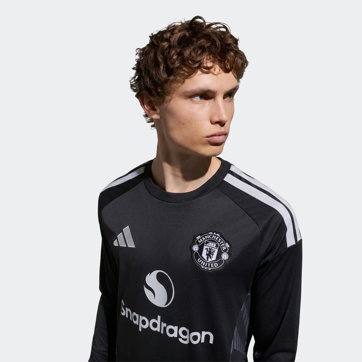 Manchester United 26/27 long sleeve goalkeeper jersey in black with white shoulder stripes and club crest, front view.