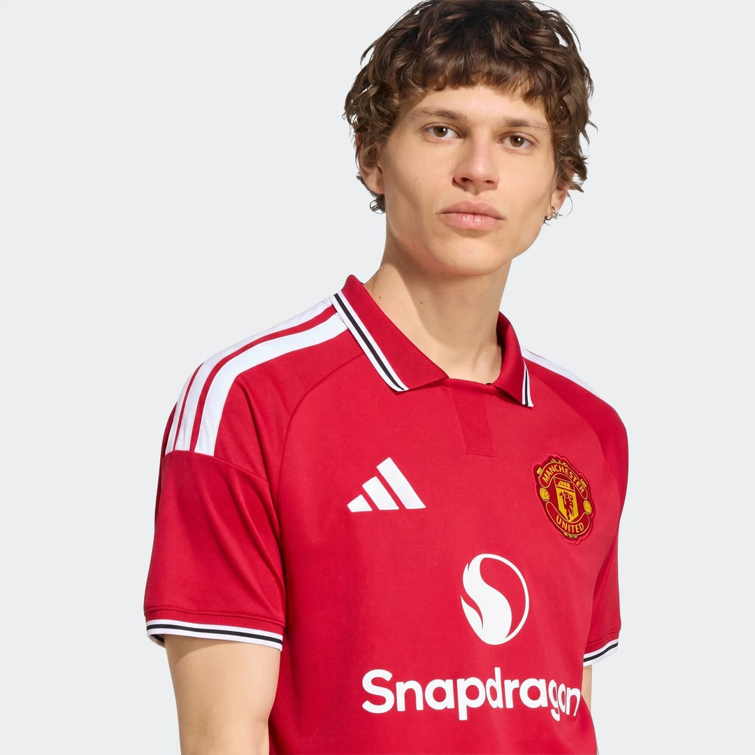 Manchester United 26/27 Home Jersey in red with white shoulder stripes, polo collar, and club crest, front view.