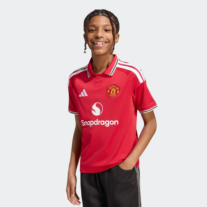 Manchester United 26/27 Home Jersey Youth in red with white shoulder stripes and club crest, front view.