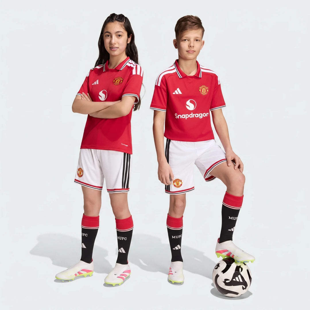 Manchester United 26/27 Home Shorts Youth in white with black side stripes and red trim, front view worn by youth.