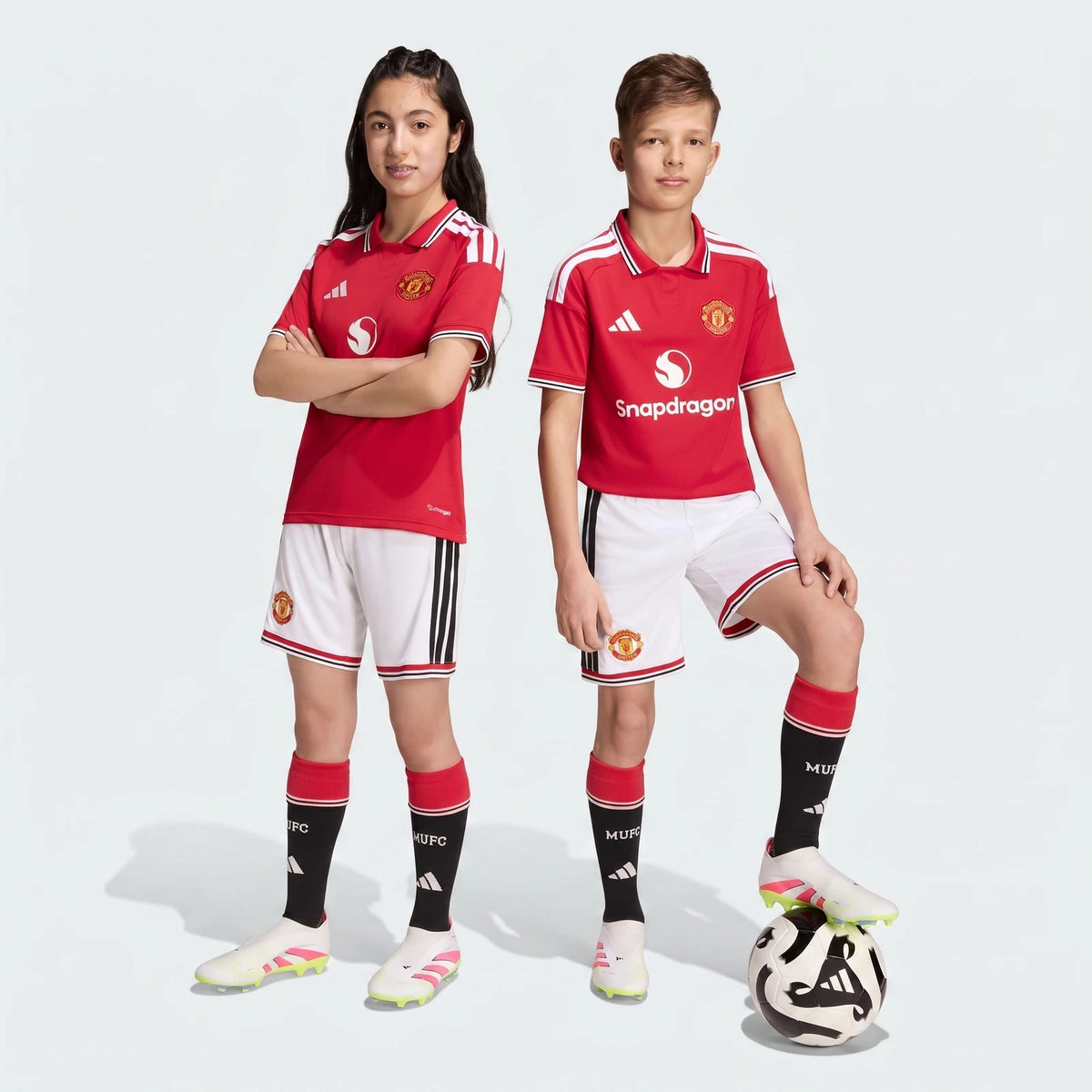 Manchester United 26/27 Home Shorts Youth in white with black side stripes and red trim, front view worn by youth.