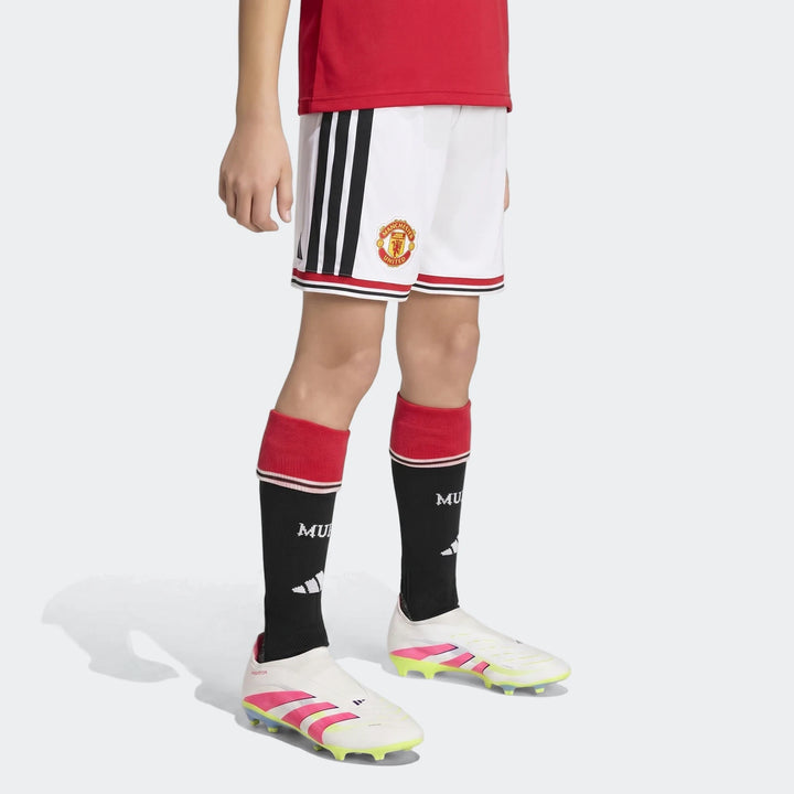 Manchester United 26/27 Home Shorts Youth in white with black side stripes and club crest, front view.