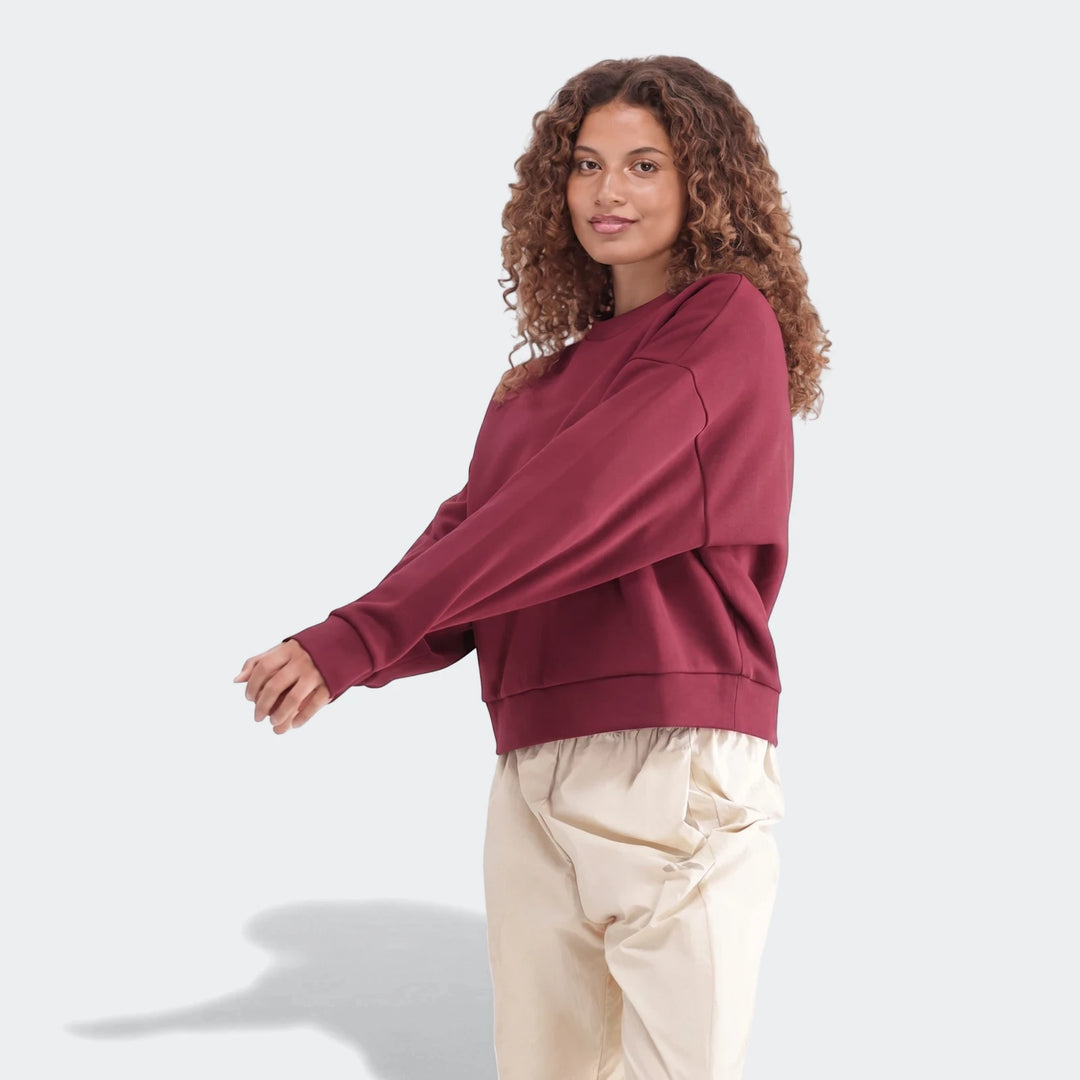 Maroon Slim Fleece Crew Sweatshirt on a woman, paired with cream pants, shown in a relaxed front view. Perfect for casual