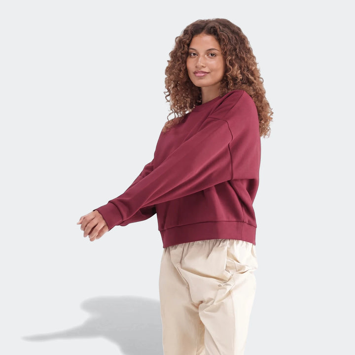 Maroon Slim Fleece Crew Sweatshirt on a woman, paired with cream pants, shown in a relaxed front view. Perfect for casual