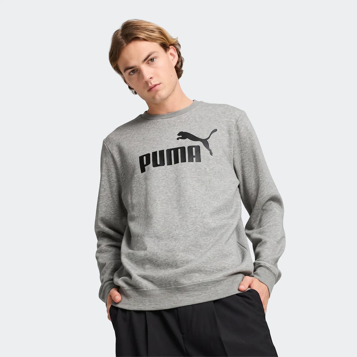 Men's grey Puma Ess No.1 Logo crewneck sweatshirt featuring a black logo on the chest, modeled from the waist up.