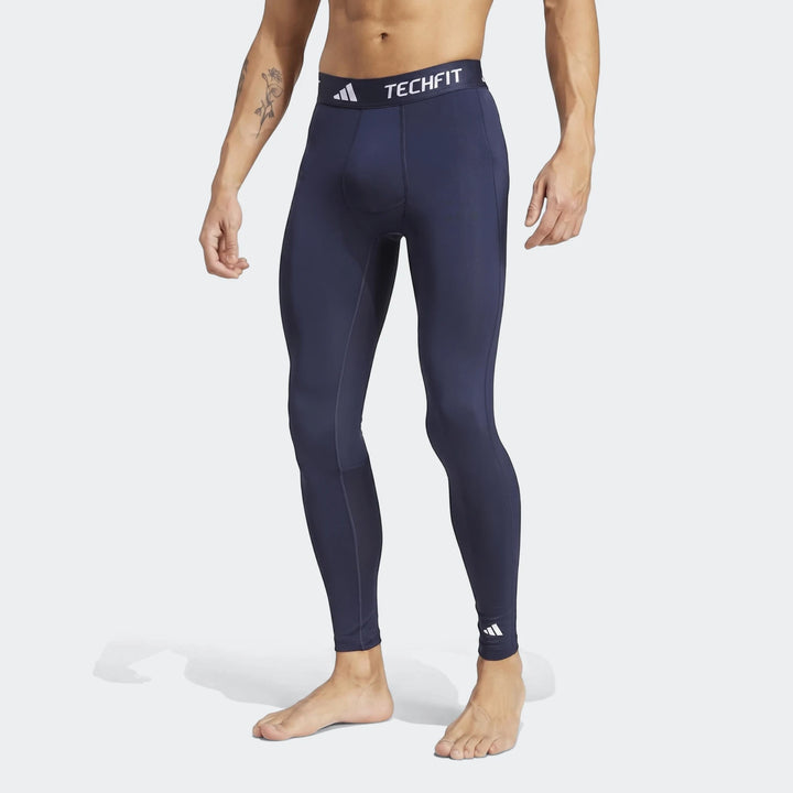 Man wearing navy blue Adidas Techfit Football Base Layer Tights, shown in a full body view.