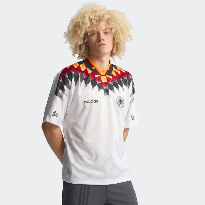 Men's white Adidas Germany 1994 Retro Home Jersey, featuring a vibrant geometric pattern and the DFB crest, worn by a model.