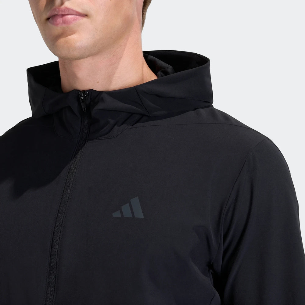 Close-up of a man wearing a black Adidas D4T Hybrid Full-Zip Hoodie, showing the front zipper and logo detail.