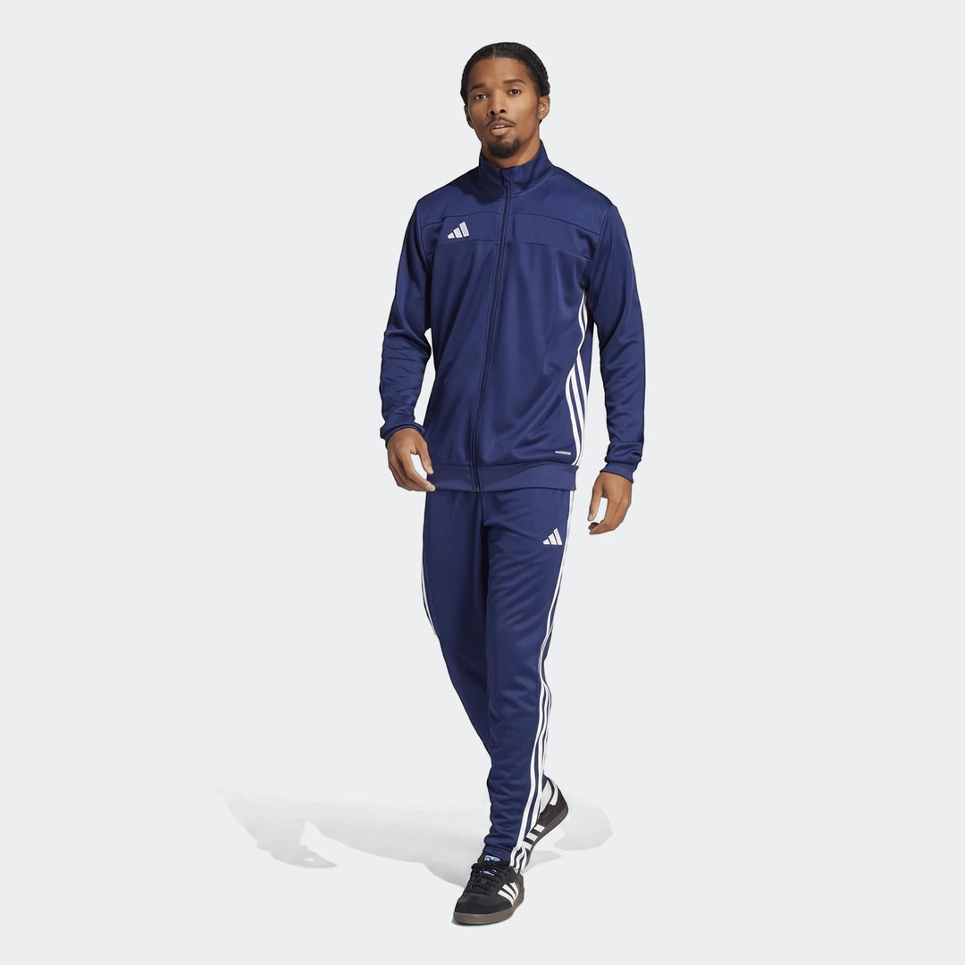Men's navy blue Adidas Tiro Essentials tracksuit, featuring a jacket and pants with white stripes, modelled front-facing.
