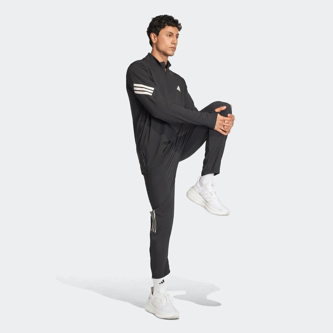 Men's black Adidas Adi365 Full-Zip Sweatshirt and matching track pants, shown on a model stretching in a full-body view.
