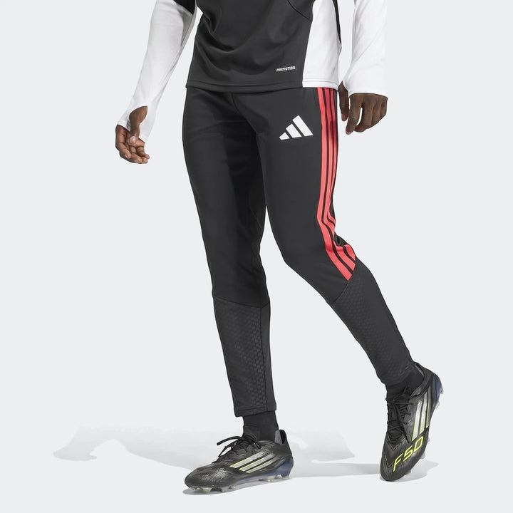 Men's black Adidas Tiro 26 Competition Training Pants with red three-stripes and a white logo, worn by a model in a dynamic