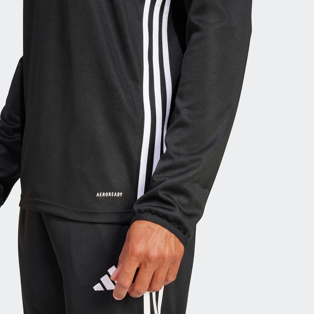 Close-up of a man wearing a black long-sleeve Adidas Tiro Essentials Track Top with white stripes and matching pants.