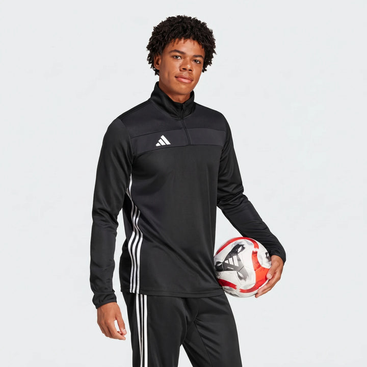 Men's black Adidas Z.N.E. half-zip track top worn by a model, featuring white stripes and logo, holding a soccer ball.
