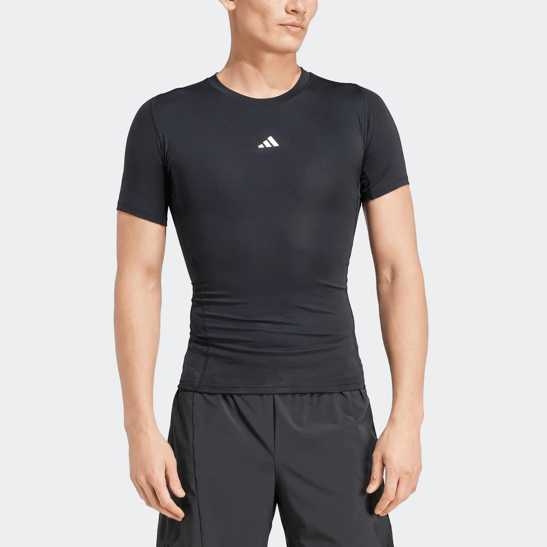 Black compression short-sleeve men's Football T-Shirt with a white Adidas logo, worn by a male model in a studio.