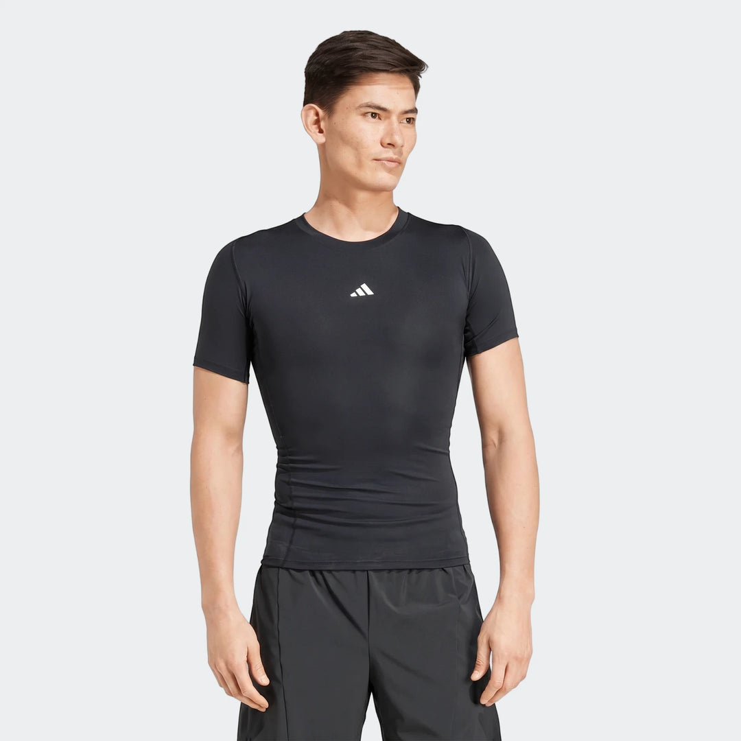 Men's black compression short sleeve football t-shirt and dark shorts on a male model, front view.