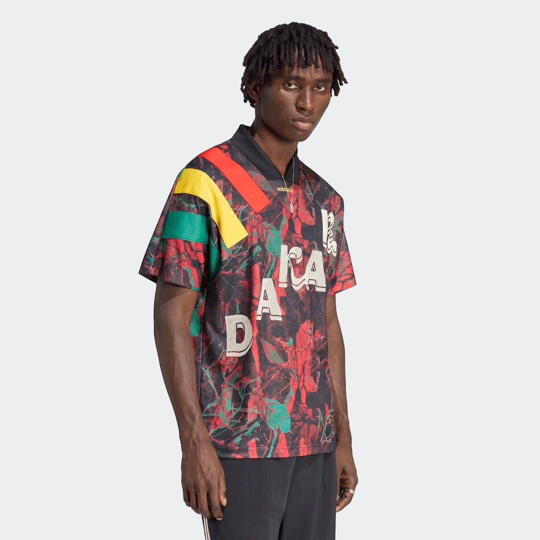 Men's black graphic football jersey featuring red, green, and yellow stripes with a vibrant leaf pattern.
