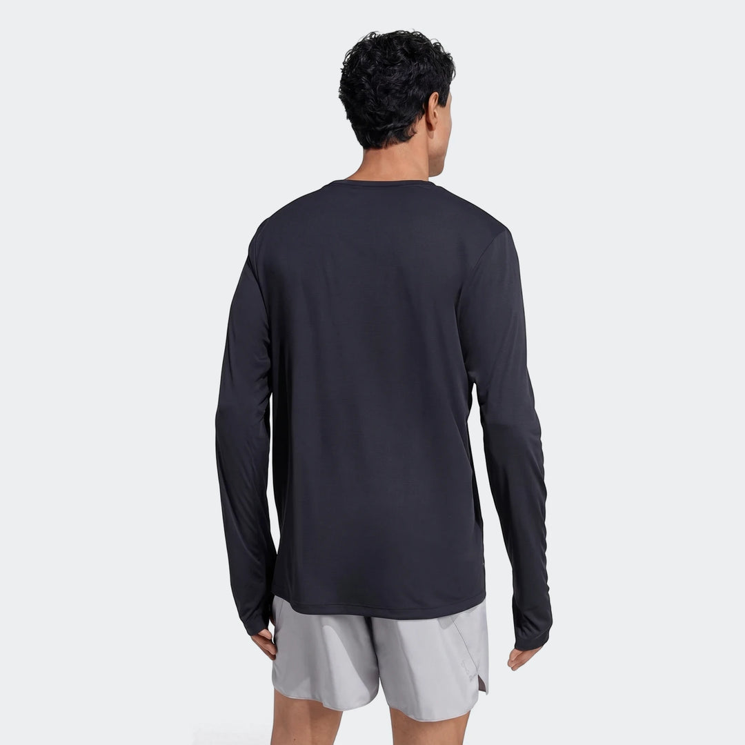 Man from back wearing a black Run Essentials Long Sleeve Top, made of performance knit fabric, paired with light grey shorts.