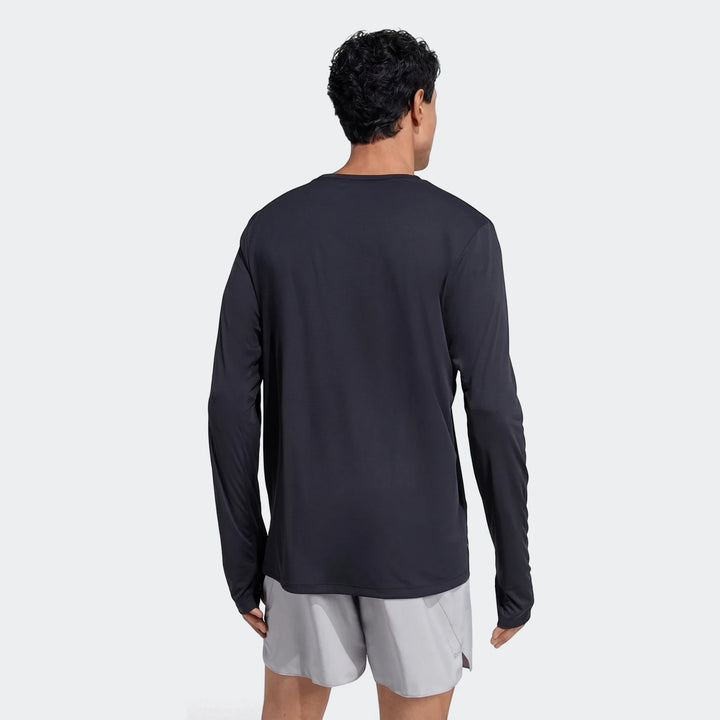 Man from back wearing a black Run Essentials Long Sleeve Top, made of performance knit fabric, paired with light grey shorts.