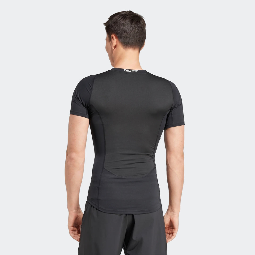Men's black short sleeve compression shirt, worn by a model from the back, showcasing athletic fit and performance fabric.