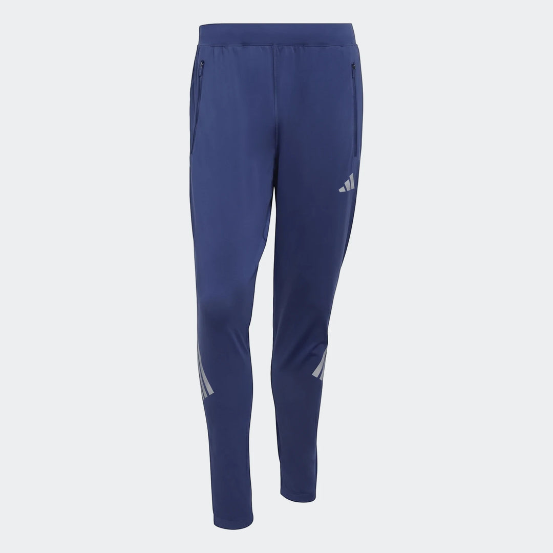 Men's blue Adidas Adi365 Track Pants, featuring zippered pockets and reflective three-bar logos on the legs, displayed
