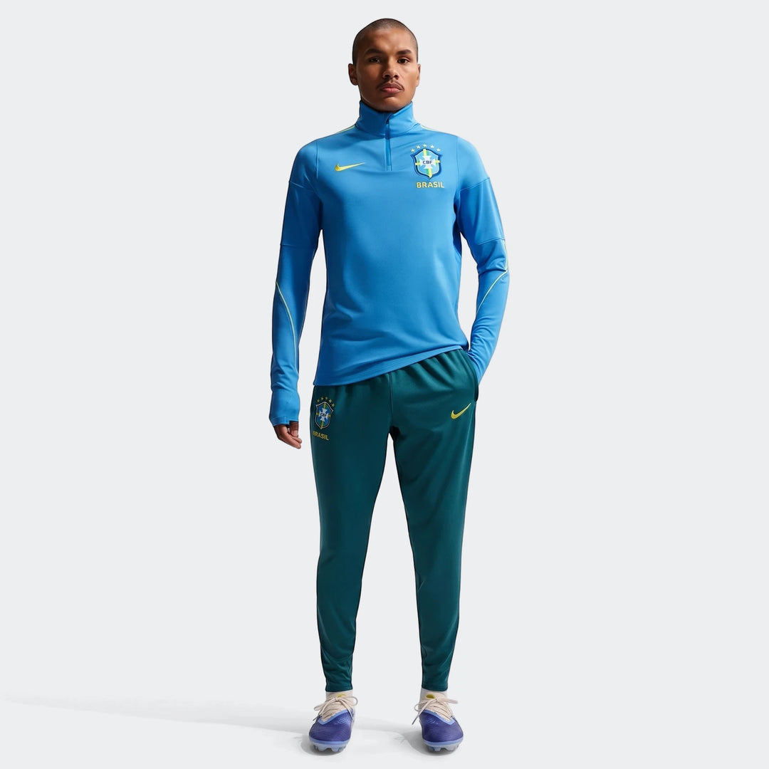 Men's Brazil Strike Nike Dri-FIT soccer training kit, featuring a blue quarter-zip top and green knit pants.