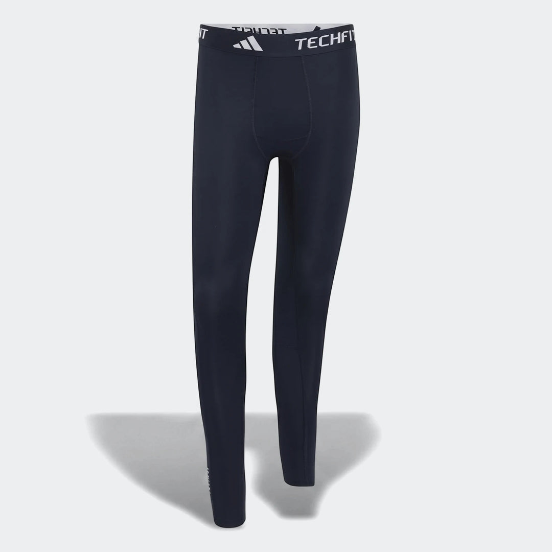 Men's dark blue Adidas TECHFIT compression tights, full-length, with white branding on the elastic waistband, front view.