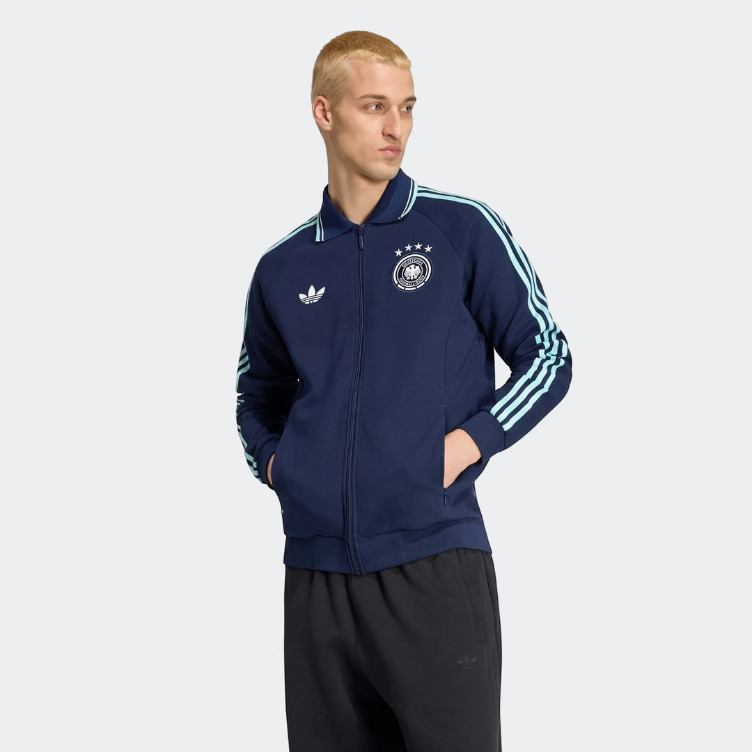 Man wearing a navy blue Adidas Germany Away Originals Jacket with light blue stripes and the German national team crest,