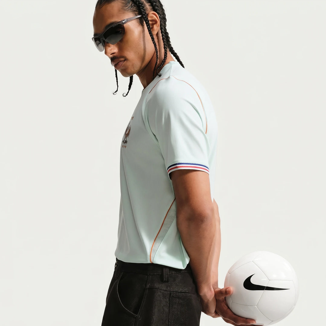 Men's Nike Dri-Fit France National Team 2026 Stadium Away soccer jersey in green, worn by a model holding a white soccer