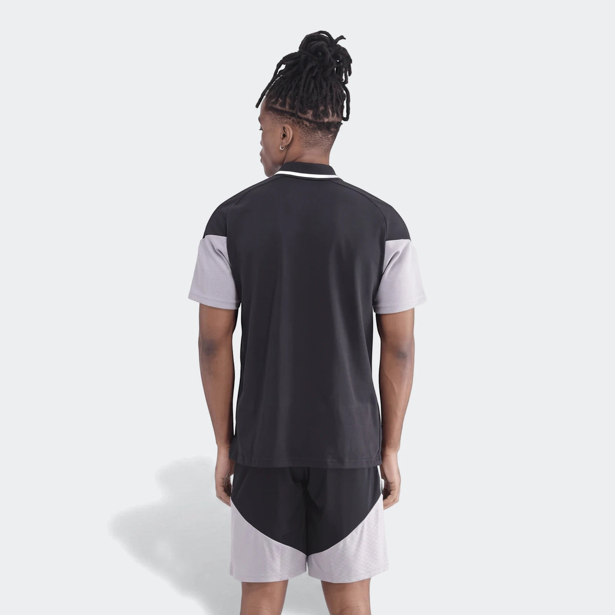 Men's Op Tiro26C Polo in a black and grey color-block design, featuring short sleeves and matching shorts, seen from the