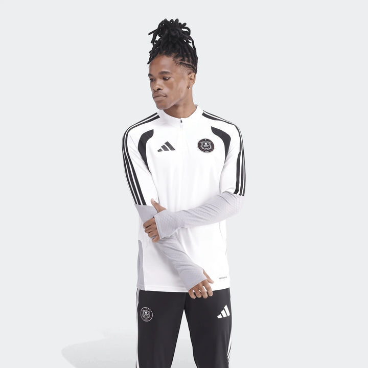 Men's white and black Adidas Op Tiro26C Top with quarter-zip, long sleeves, and club crest, worn by a model with dreadlocks.
