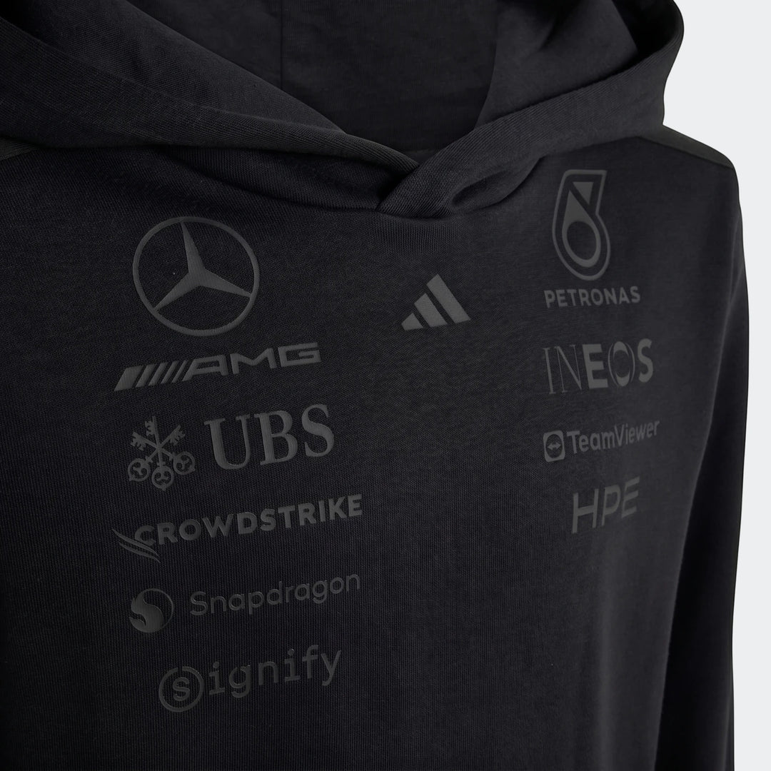 Close-up of a black Mercedes-AMG Petronas Formula 1 Team Night Driver Youth Hoodie, featuring various sponsor logos.