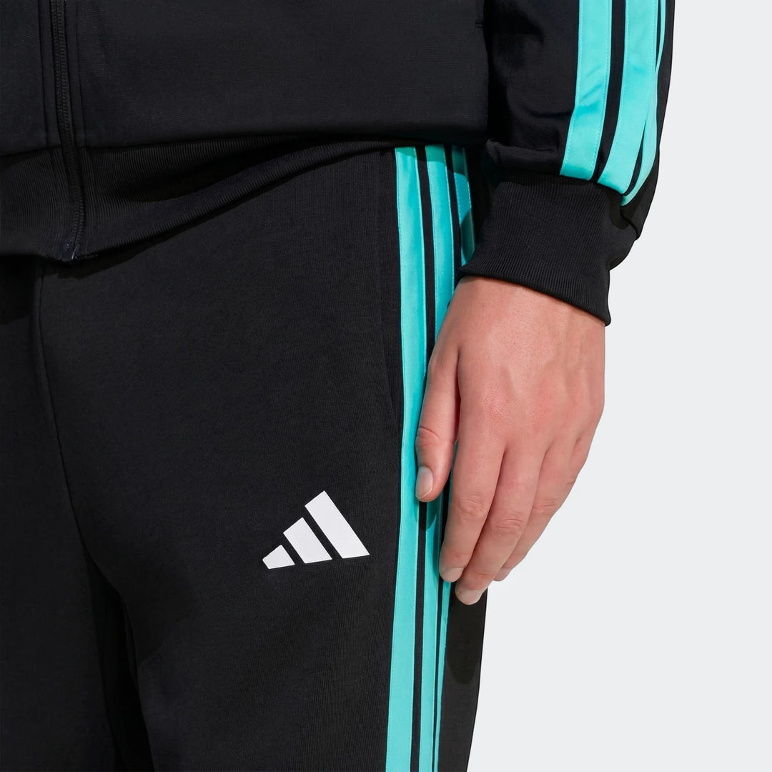 Close-up of black Mercedes-Amg Petronas Formula 1 Team Dna Pants with teal side stripes and white Adidas logo, worn by a