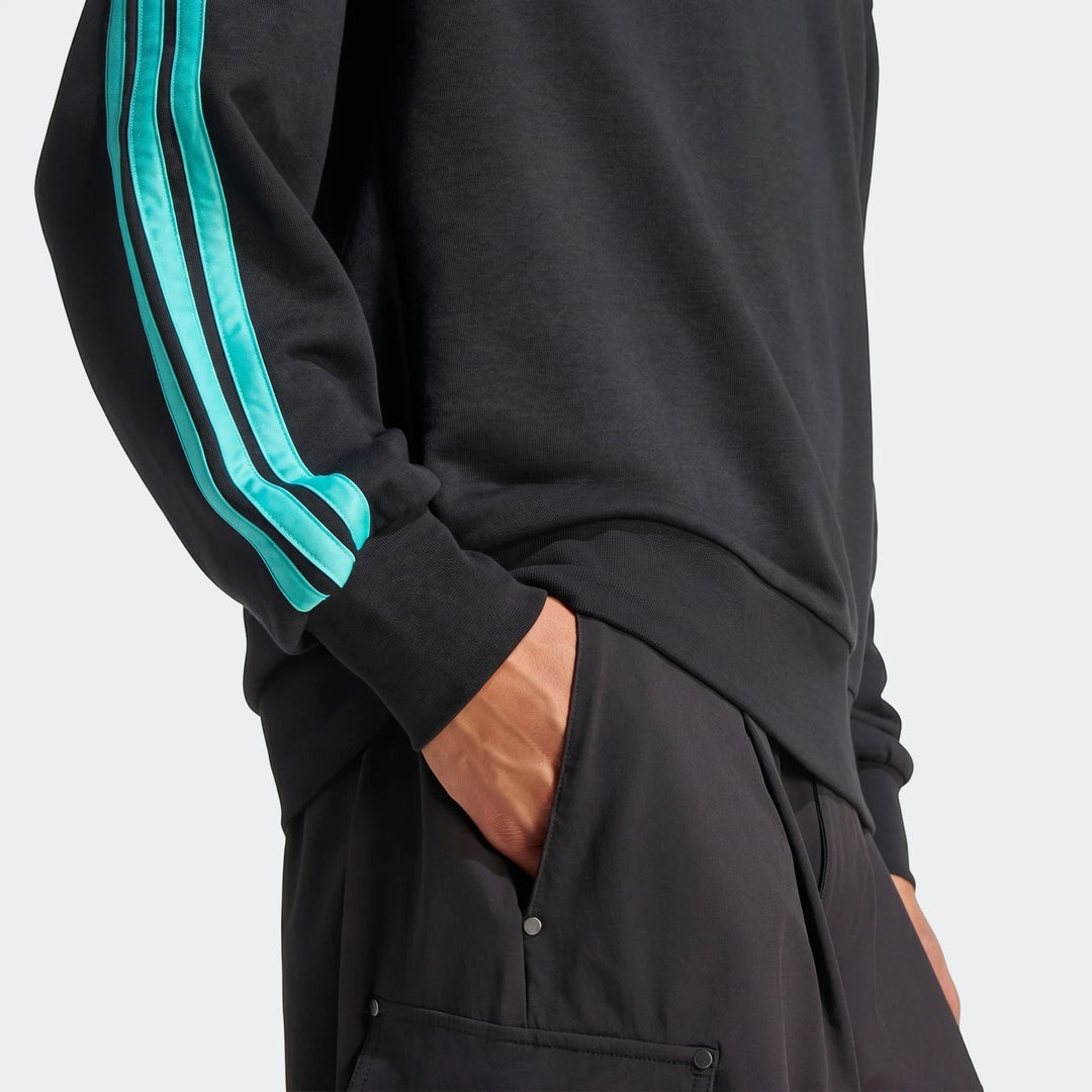 Close-up of the Mercedes-AMG Petronas Formula 1 Team DNA Sweatshirt in black with turquoise stripes on the sleeve, worn by a