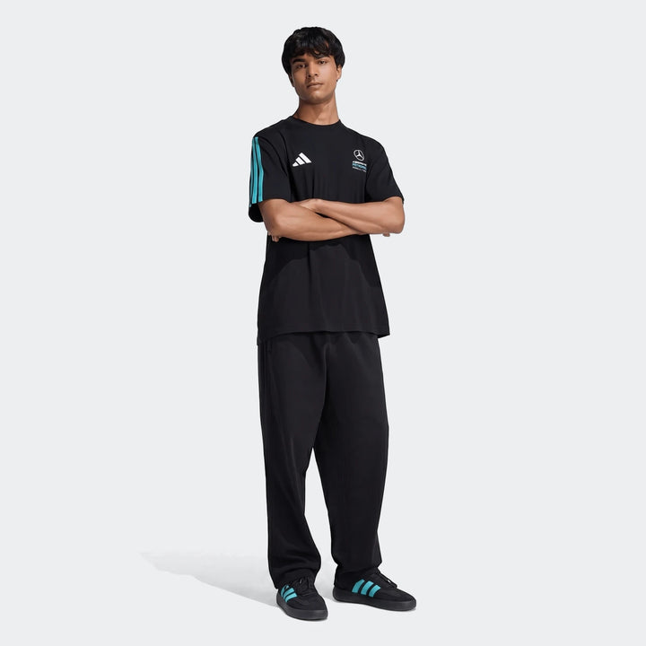 Male model wearing a black Mercedes-AMG Petronas Formula 1 Team DNA T-Shirt with teal stripes and black athletic pants and