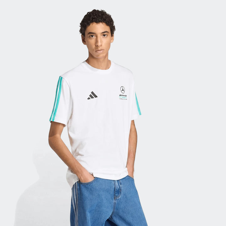 Male model wearing a white Mercedes-AMG Petronas Formula 1 Team DNA T-Shirt with teal stripes and blue jeans.