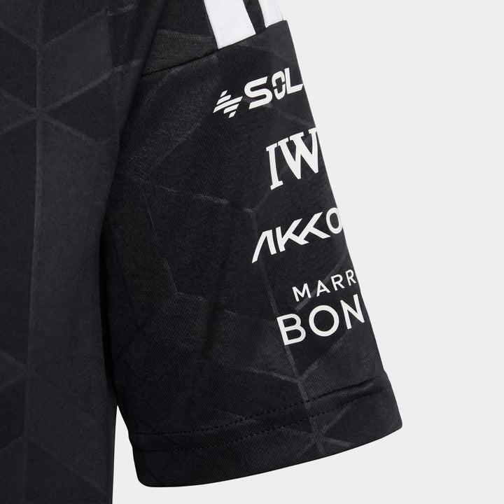 Close-up of a black Mercedes-AMG Petronas Formula 1 Team Driver Youth jersey sleeve, featuring white sponsor logos and team