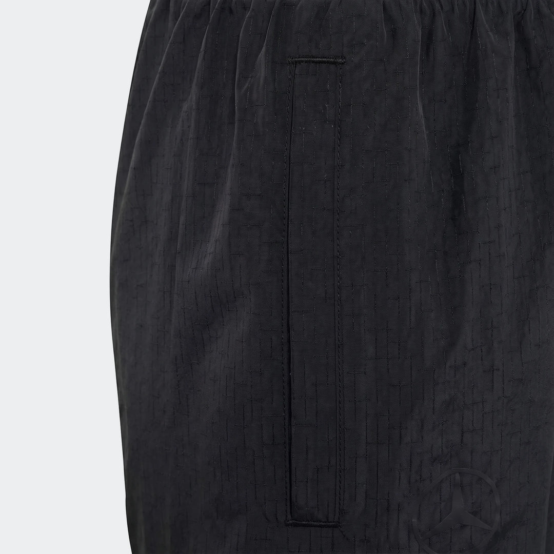 Close-up of Mercedes-Amg Petronas Formula 1 Team Night Woven Pants for youth, in black with a subtle grid pattern fabric and