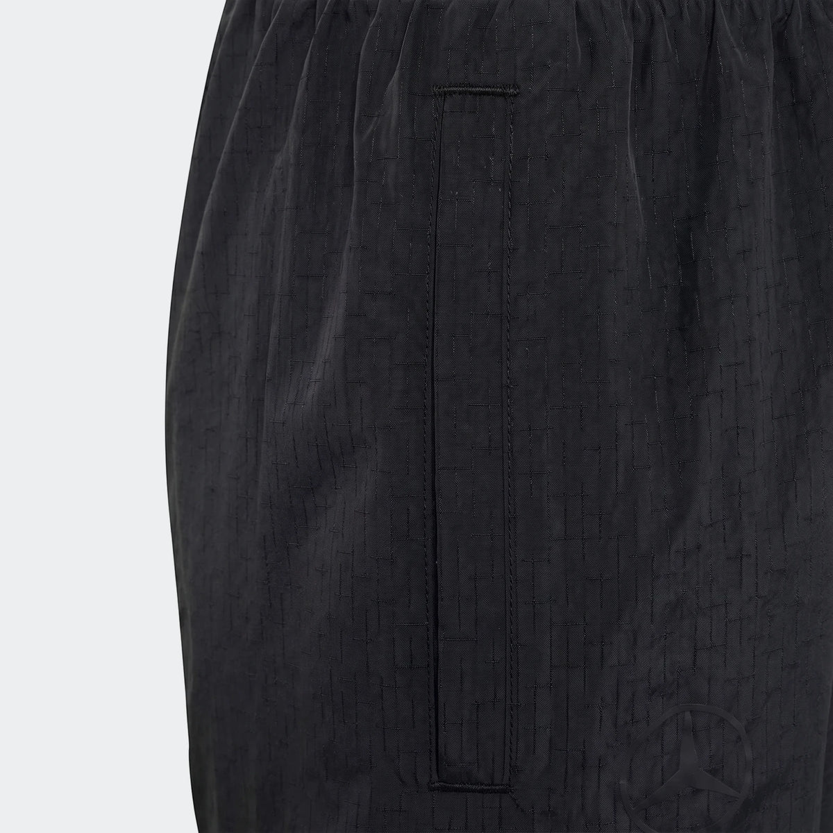 Close-up of Mercedes-Amg Petronas Formula 1 Team Night Woven Pants for youth, in black with a subtle grid pattern fabric and