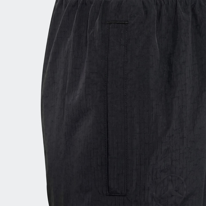 Close-up of Mercedes-Amg Petronas Formula 1 Team Night Woven Pants for youth, in black with a subtle grid pattern fabric and