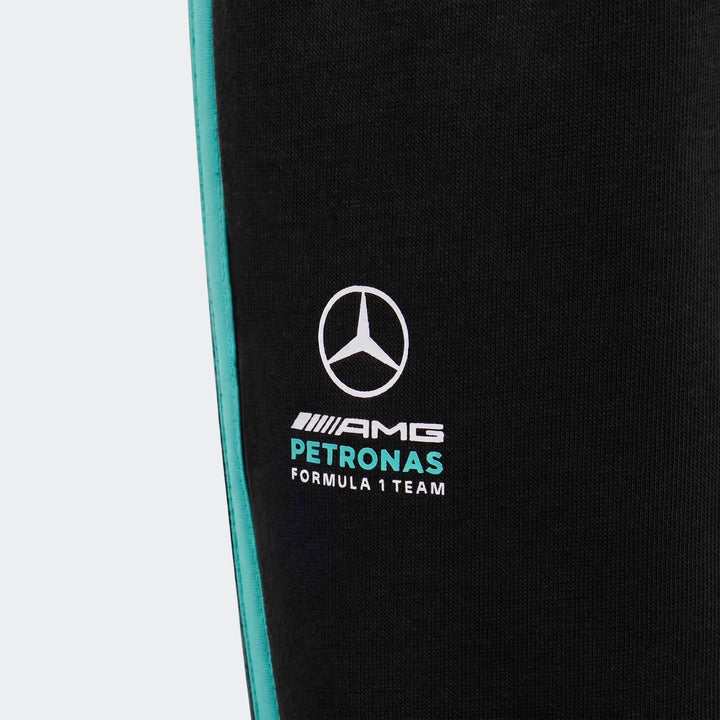 Close-up of Mercedes-AMG Petronas Formula 1 Team DNA black pants for kids, featuring a turquoise side stripe and team logo.